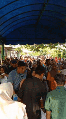 Crowd gathers under canopies for distribution event in Lhokseumawe