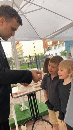 Street magician entertains children with card tricks in Yekaterinburg