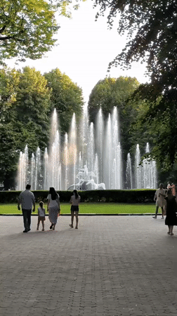 Lviv park afternoon: fountain sculptures, croissant café, summer strollers