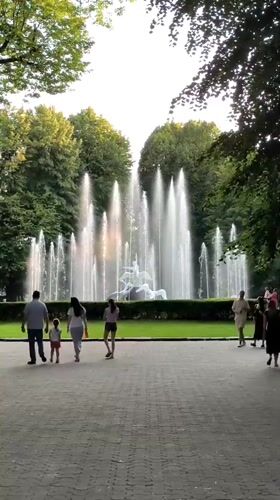 Lviv park afternoon: fountain sculptures, croissant café, summer strollers