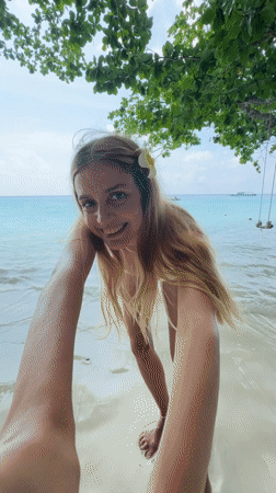 Woman enjoys beach day with drink in Thailand