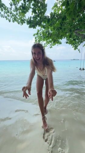 Woman enjoys beach day with drink in Thailand