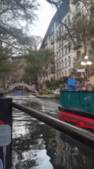 Tourists explore San Antonio River Walk during evening hours