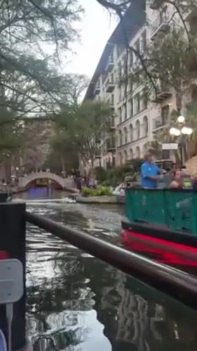 Tourists explore San Antonio River Walk during evening hours