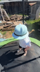 Mother and child play on backyard trampoline in Russia
