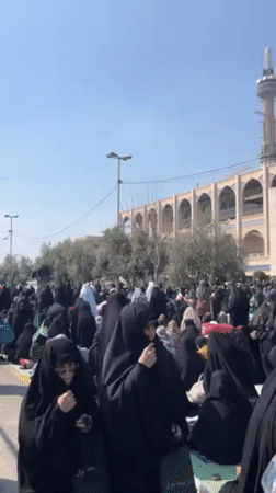 Women gather near religious building in Tehran public space