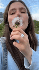 Woman blows dandelion seeds in Montenegro park moment