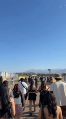 Festival crowd walks toward outdoor event in Indio