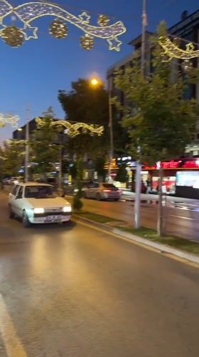 Festive string lights glow along an Osmaniye street at dusk