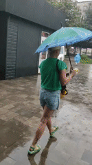 Rainy day foot traffic on wet Kamianske sidewalks