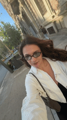 Woman walks past murals near Academy of Athens