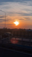 Highway sunset observed in Warsaw displaying orange-blue sky