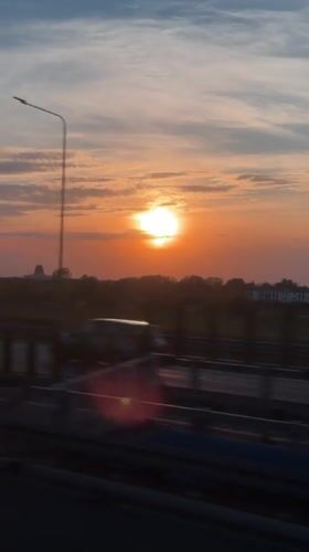 Highway sunset observed in Warsaw displaying orange-blue sky