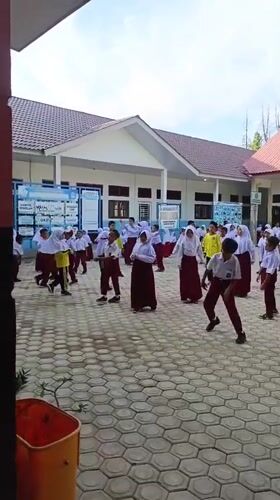 Students in uniform doing outdoor activity in Indonesian school courtyard