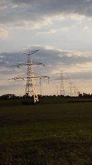 Green cropfields and pylons under a warm autumn sky in Hospozín