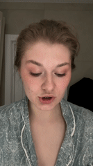 Woman tries on gold earrings in Kazan bathroom