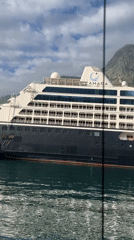 Sailboat passes AZAMARA cruise ship in Kotor waters