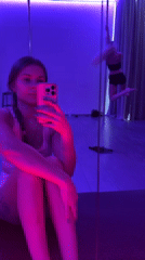 Women practice pole dancing, take selfies in neon studio