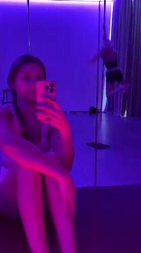 Women practice pole dancing, take selfies in neon studio