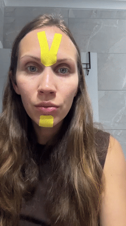 Woman applies kinesiology tape to face in Fethiye bathroom