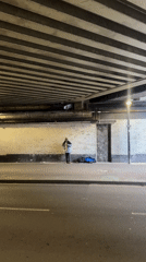 Street musician plays saxophone under London bridge