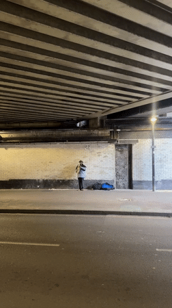 Street musician plays saxophone under London bridge