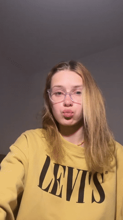 Woman styles hair with straightener in Kragujevac apartment