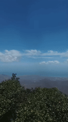 Woman poses on scenic hillside road overlooking Las Piedras