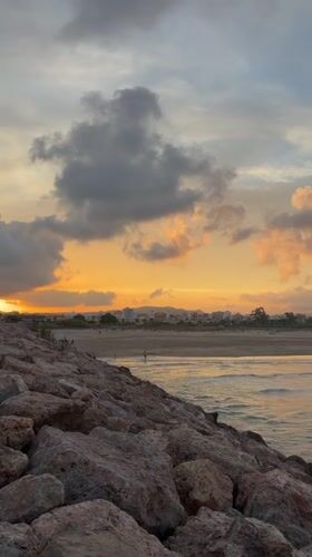 Sunset watcher observed on Sagunto breakwater during evening hours