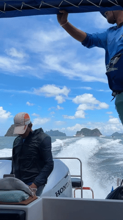 Speedboat cruising past limestone karsts near Krasom, Thailand