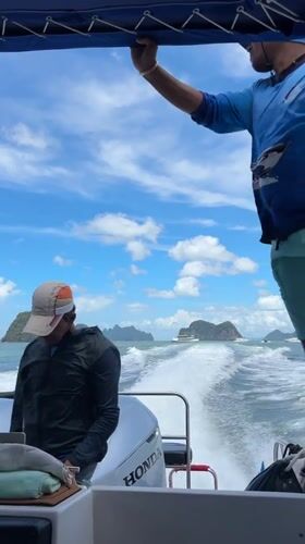 Speedboat cruising past limestone karsts near Krasom, Thailand