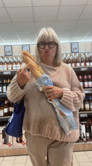 Woman shops for wine and bread in Saint-Galmier grocery store