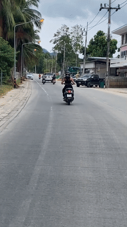 Morning street activity captured on tropical road in Thailand