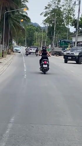 Morning street activity captured on tropical road in Thailand