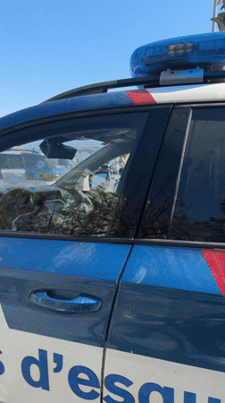 Police van stationed at busy Barcelona beach during sunny day