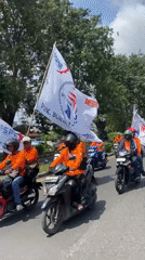 Motorcycle procession with flags observed in Tebel, Indonesia