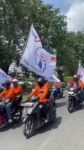 Motorcycle procession with flags observed in Tebel, Indonesia