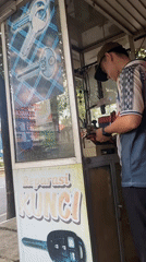 Street-side key cutting kiosk scene in Banjarbaru, Indonesia