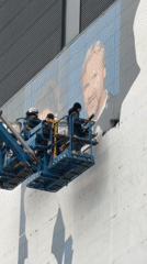 Workers use crane lift for building mural in NYC