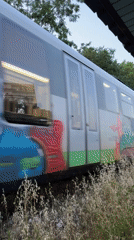Graffiti-tagged passenger train passing through Lovech, Bulgaria