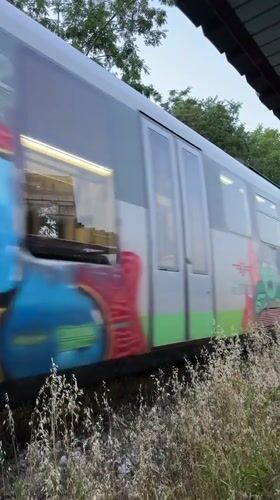 Graffiti-tagged passenger train passing through Lovech, Bulgaria