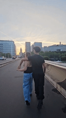 Dusk on a Paris bridge, city skyline and street life