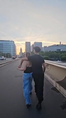 Dusk on a Paris bridge, city skyline and street life