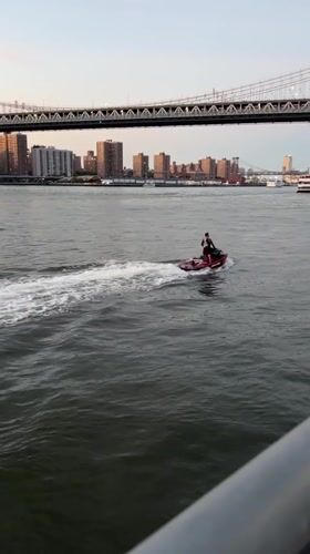 Brooklyn waterfront at golden hour — bridges, boats, and a pier proposal