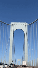 Traffic flows across New York bridge on clear afternoon