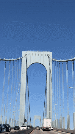 Traffic flows across New York bridge on clear afternoon