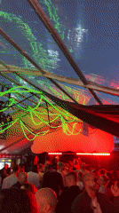 Festive indoor crowd under a lit transparent tent in Düsseldorf
