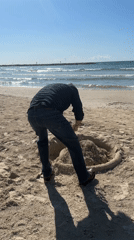 Man digs large hole on Tel Aviv beach