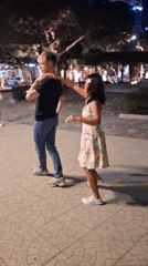 Couples partner dancing on a lit plaza in Nha Trang at night