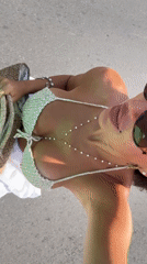Woman in crocheted bikini walks Kuta Selatan pathway early morning
